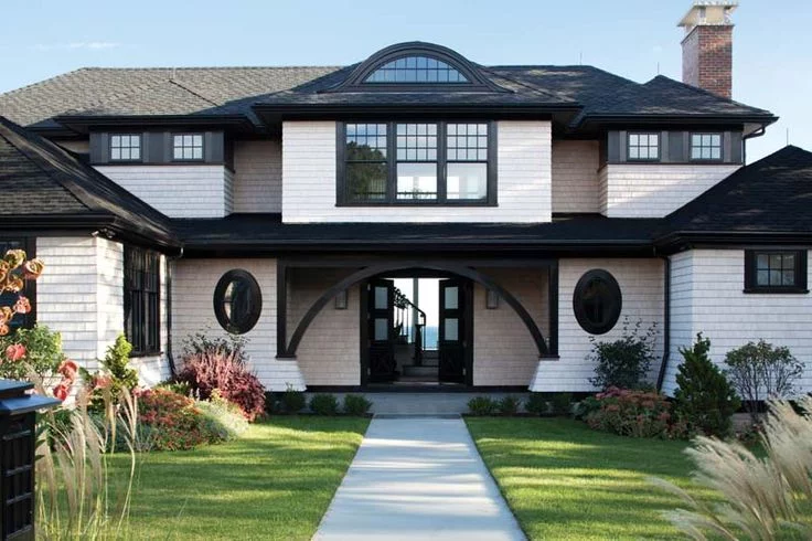 A white home with black trim and oval windows