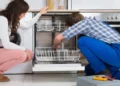 A men and women trying to fix a broken appliance in the home - Appliance Repairs