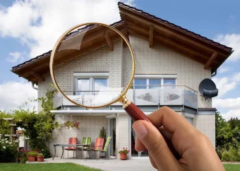 A guy Inspecting the house through a magnifying glass