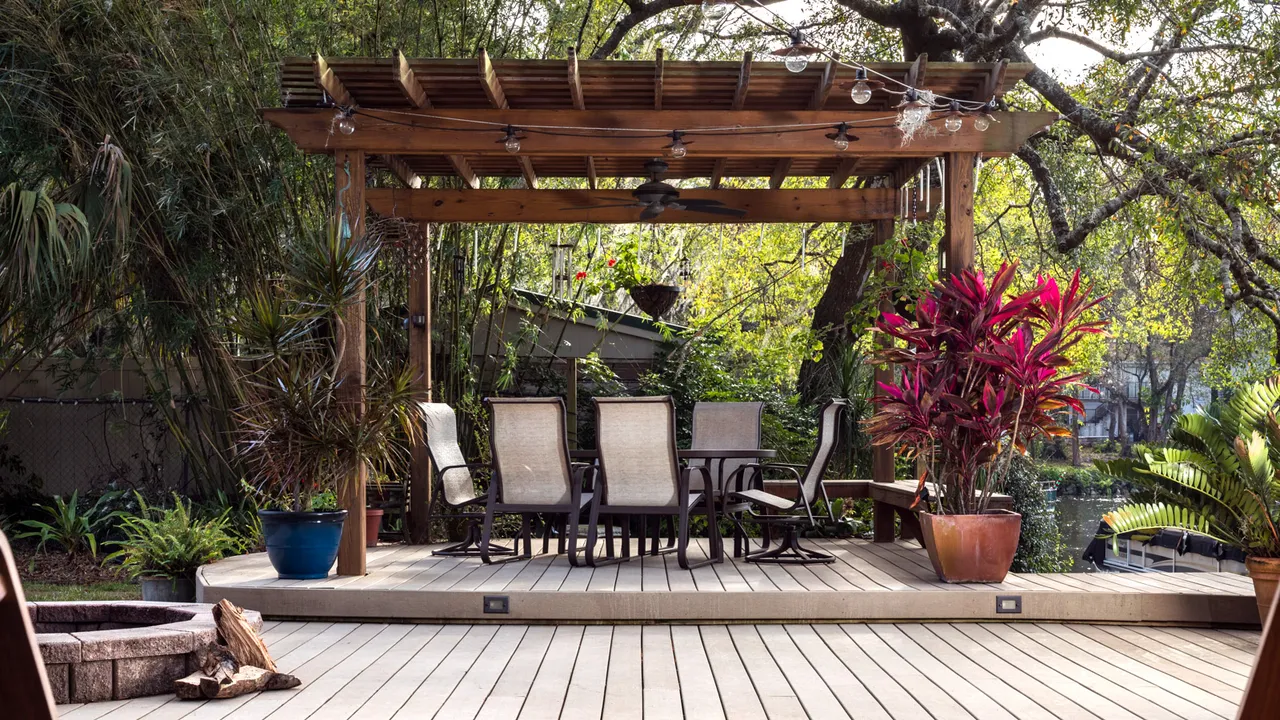 A deck with sitting chairs and planters- deck ideas for backyard