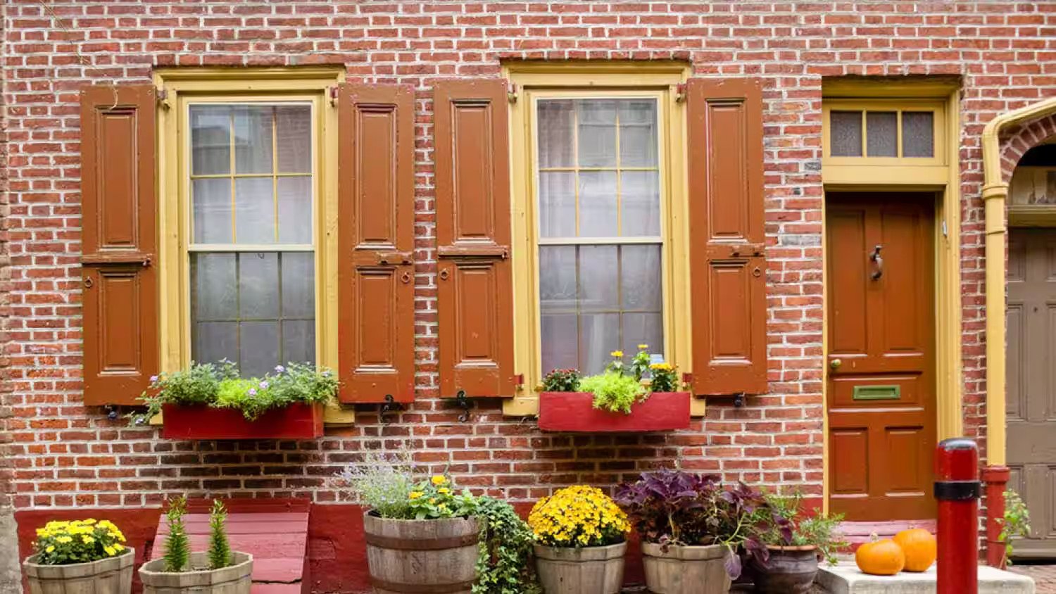 Yellow trim color with red brick house