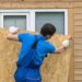 A Person boarding up the window for protecting his home from hurricane